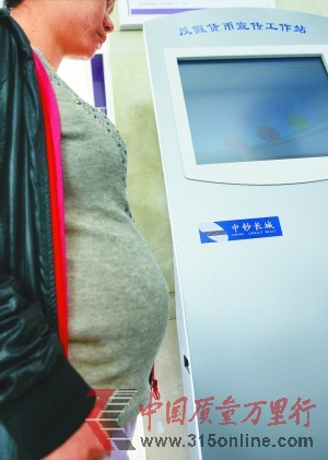 　　王女士在反假貨幣工作站旁。深圳晚報記者 丁開 攝