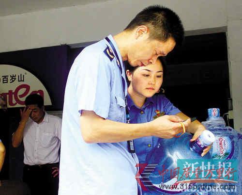 ■執(zhí)法人員在店外堆放的空桶中,找到了一個標有問題生產(chǎn)許可證號的塑料桶。新快報記者付玉良/攝 ■執(zhí)法人員在店外堆放的空桶中,找到了一個標有問題生產(chǎn)許可證號的塑料桶。新快報記者付玉良/攝
